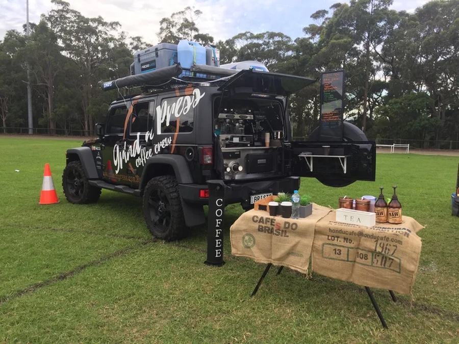 An SUV converted for coffee service, tailgate raised over the serving bench.