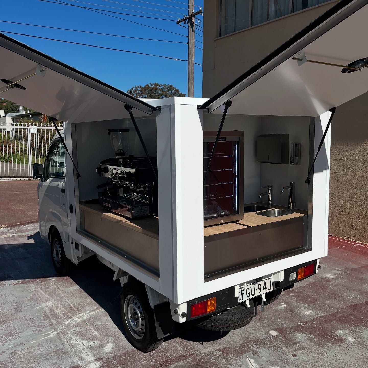 White dual-cab ute, rear canopy fit-out, machine and fridge