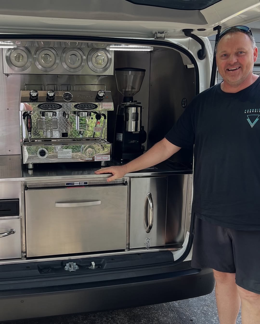 Rear hatch coffee set-up with operator standing beside it