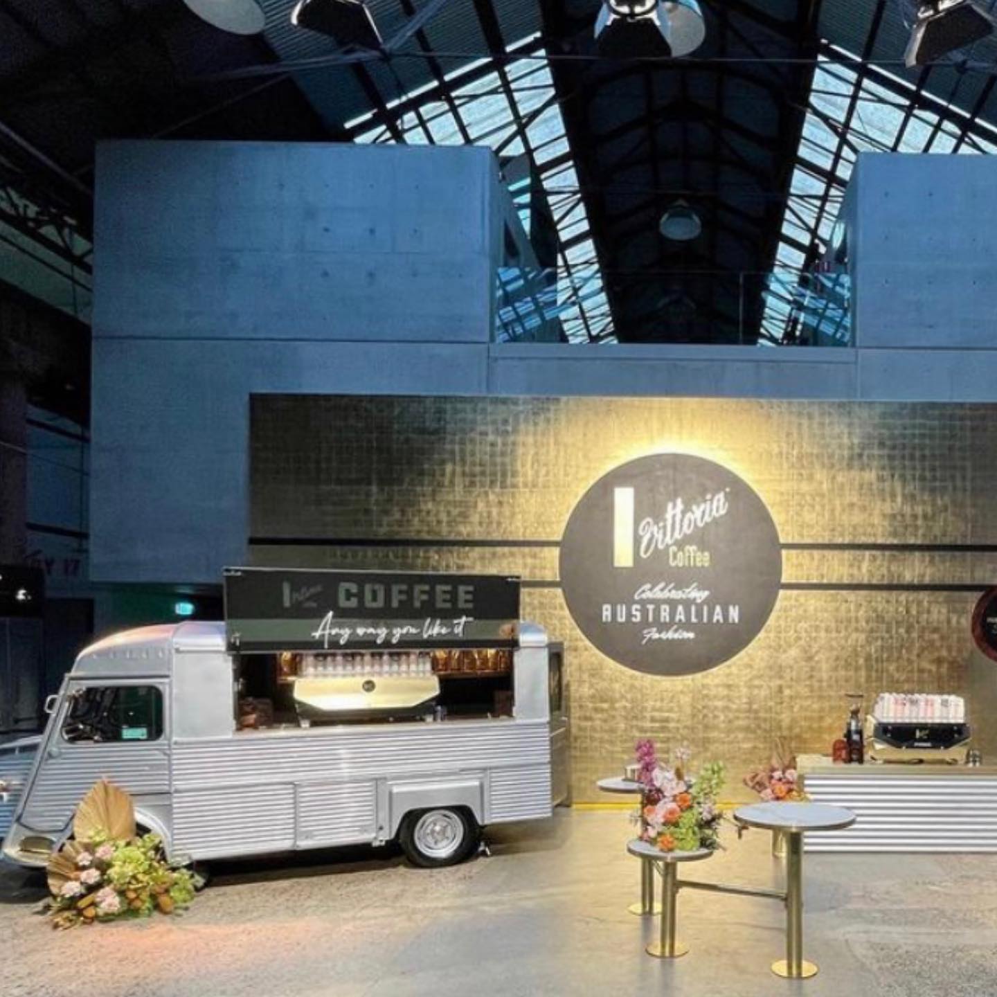 Restored Citroen HY van at an indoor event, gold branding signage