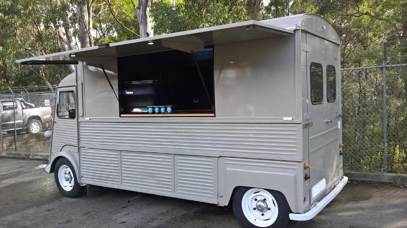 Citroen HY coffee van, servery hatch open, parked among trees