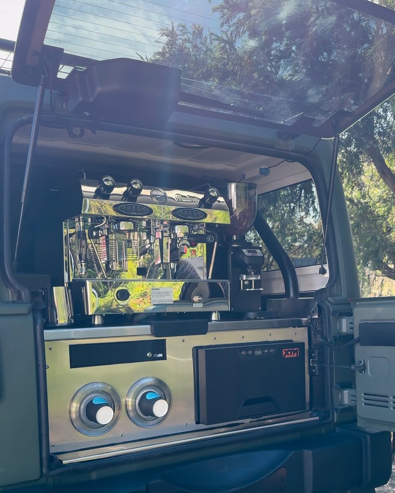 A Jeep Wrangler with its rear hatch raised over a fitted espresso bench.